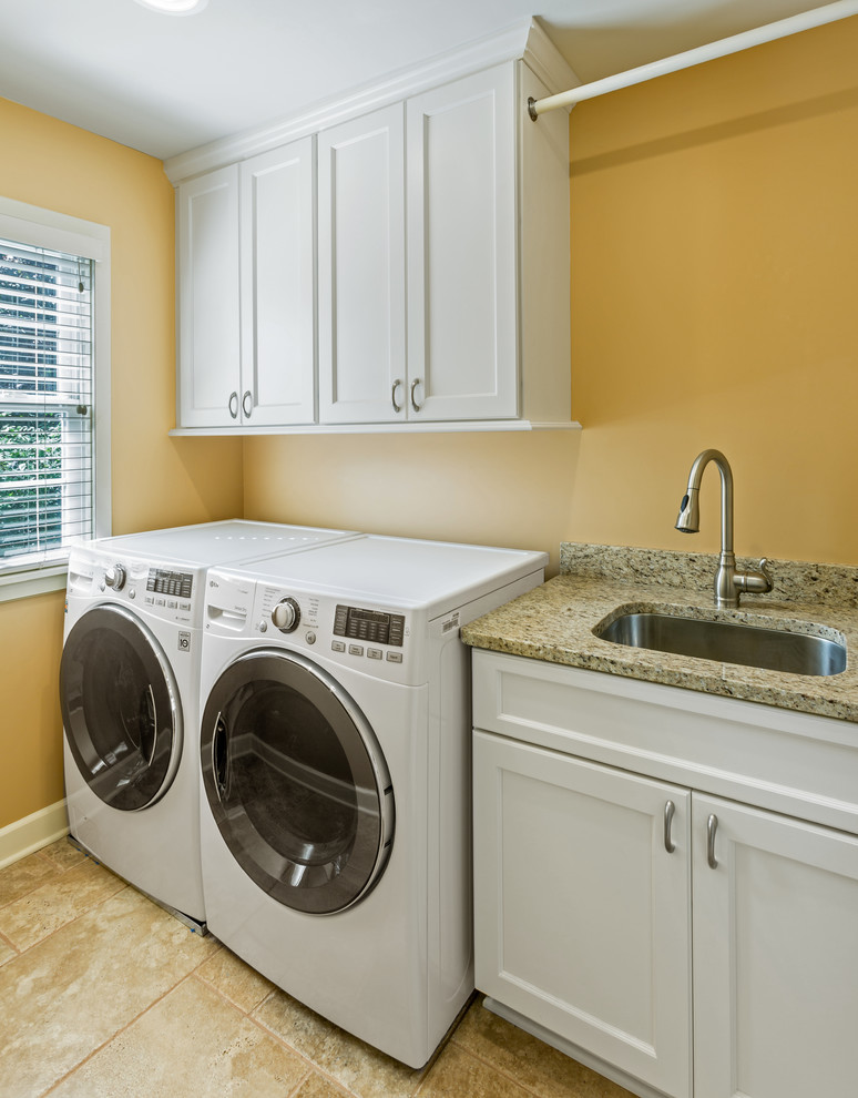 Idéer för små vintage linjära tvättstugor enbart för tvätt, med en undermonterad diskho, luckor med infälld panel, vita skåp, bänkskiva i kvarts, klinkergolv i porslin, en tvättmaskin och torktumlare bredvid varandra och orange väggar