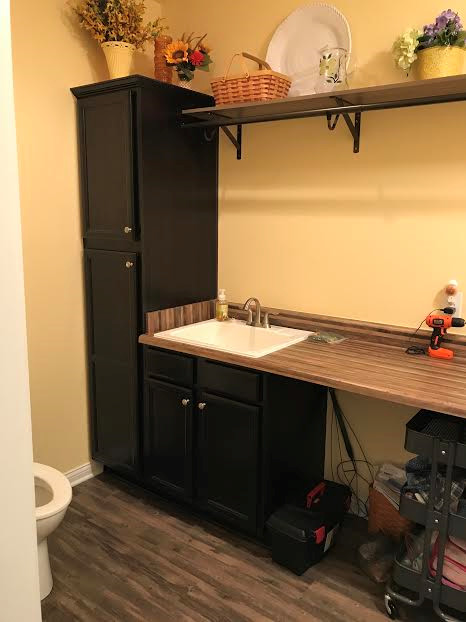 Photo of an utility room in Indianapolis with a built-in sink, flat-panel cabinets, dark wood cabinets and laminate countertops.