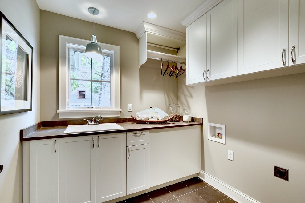 Inspiration for a medium sized classic galley utility room in Minneapolis with a built-in sink, raised-panel cabinets, white cabinets, composite countertops, beige walls and ceramic flooring.