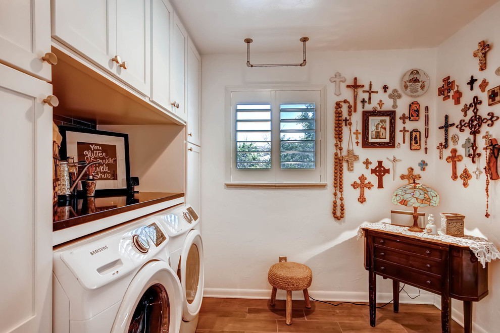 Klassisk inredning av en mellanstor parallell tvättstuga enbart för tvätt, med skåp i shakerstil, vita skåp, bänkskiva i täljsten, vita väggar, klinkergolv i keramik och en tvättmaskin och torktumlare bredvid varandra