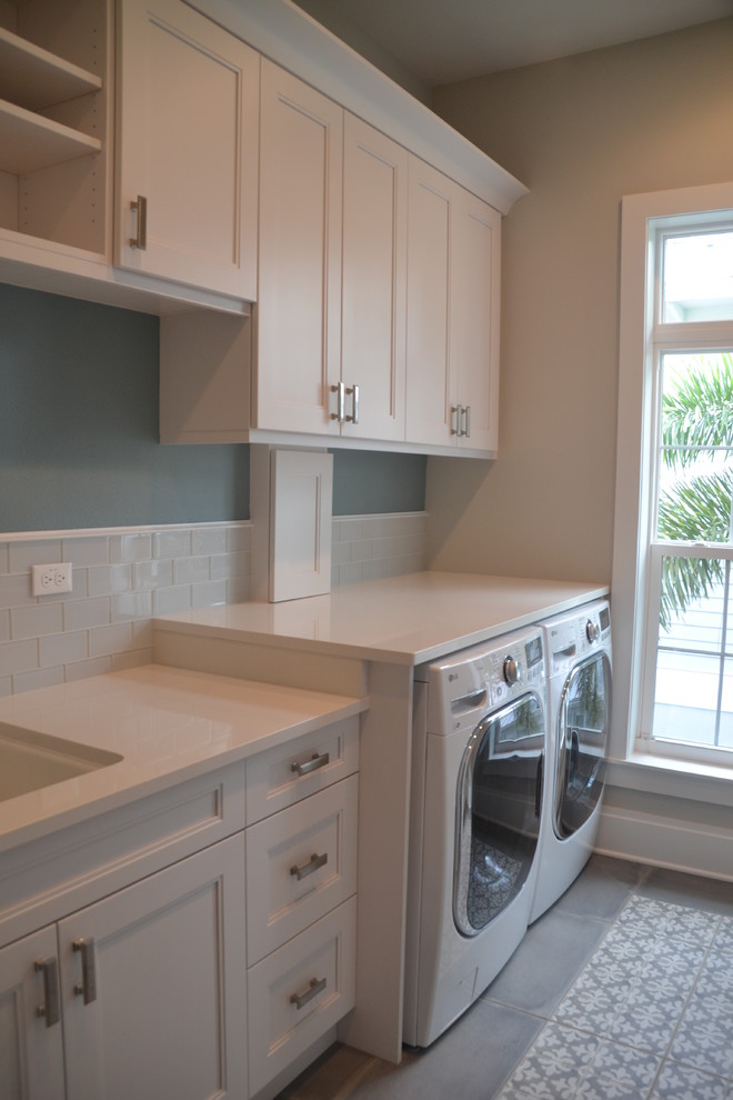 This is an example of a medium sized single-wall utility room in Tampa with a submerged sink, shaker cabinets, white cabinets, quartz worktops, blue walls, porcelain flooring and a side by side washer and dryer.