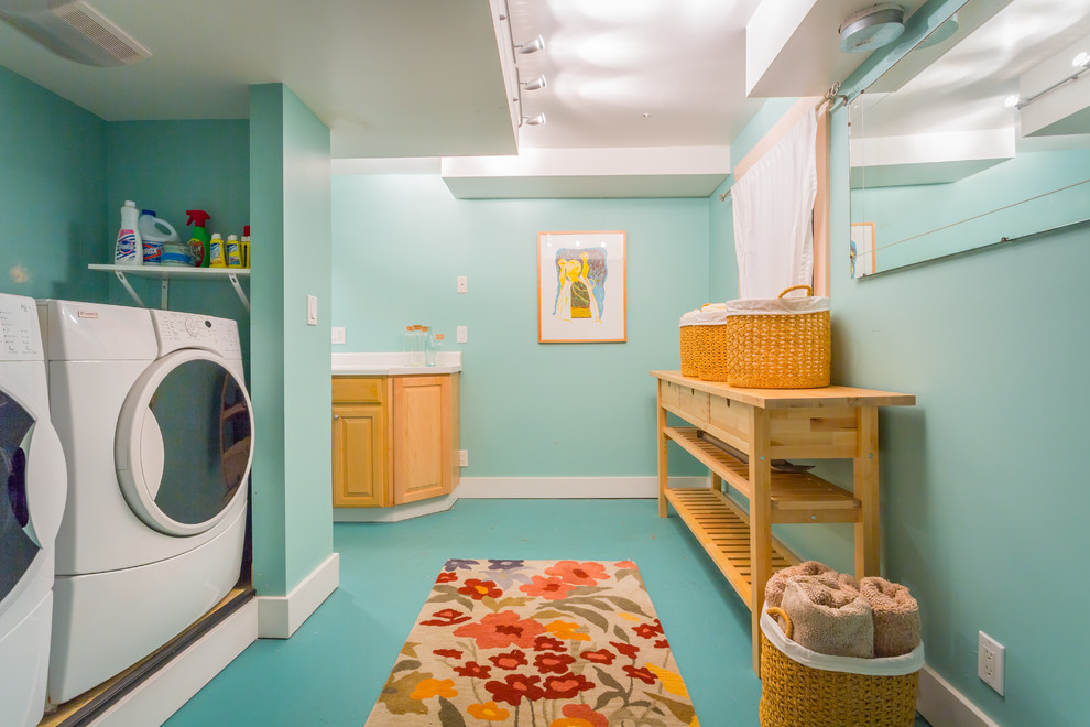 Idéer för maritima tvättstugor, med blå väggar, en tvättmaskin och torktumlare bredvid varandra och blått golv