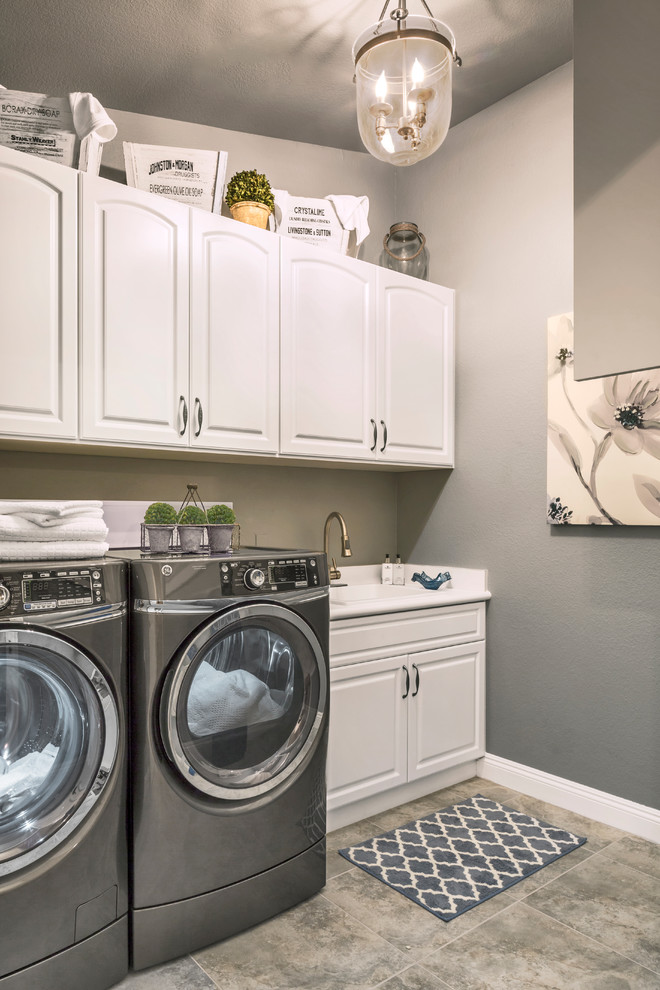 Idéer för små vintage vitt tvättstugor enbart för tvätt, med luckor med upphöjd panel, vita skåp, laminatbänkskiva, grå väggar, klinkergolv i keramik, en tvättmaskin och torktumlare bredvid varandra, grått golv och en nedsänkt diskho