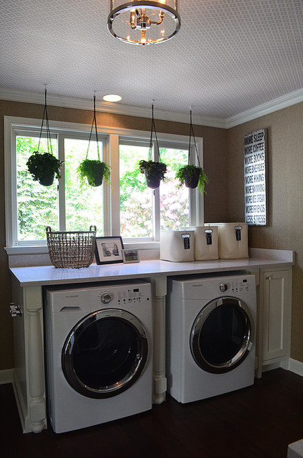 Idéer för en mellanstor klassisk linjär tvättstuga enbart för tvätt, med bruna väggar, mörkt trägolv, en tvättmaskin och torktumlare bredvid varandra, skåp i shakerstil, vita skåp och bänkskiva i kvarts