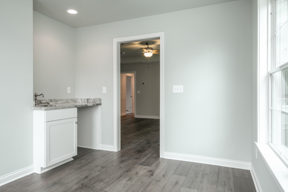 Traditional separated utility room in Louisville with a built-in sink, recessed-panel cabinets, white cabinets, granite worktops, green walls, medium hardwood flooring, brown floors and grey worktops.