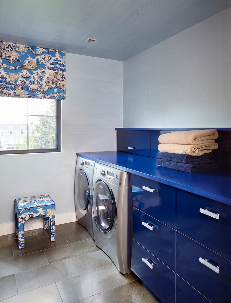 ニューヨークにあるエクレクティックスタイルのおしゃれな洗濯室 (I型、フラットパネル扉のキャビネット、青いキャビネット、青い壁、左右配置の洗濯機・乾燥機、青いキッチンカウンター) の写真