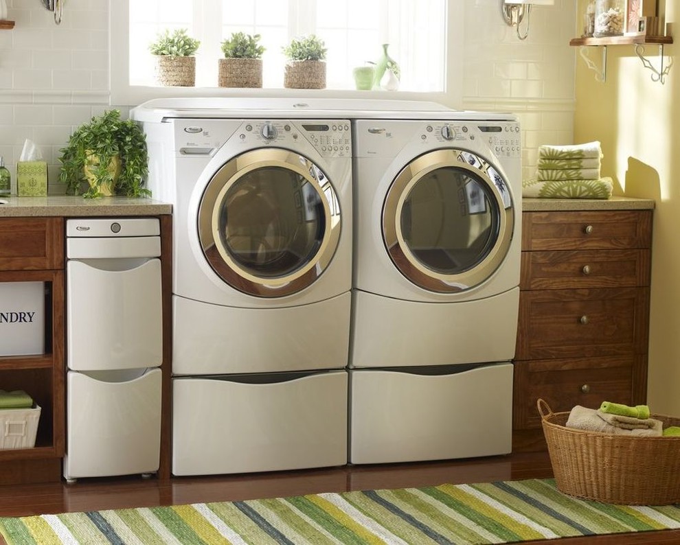 Mid-sized trendy single-wall dark wood floor and beige floor dedicated laundry room photo in Boston with shaker cabinets, dark wood cabinets, laminate countertops, a side-by-side washer/dryer, an undermount sink and beige walls