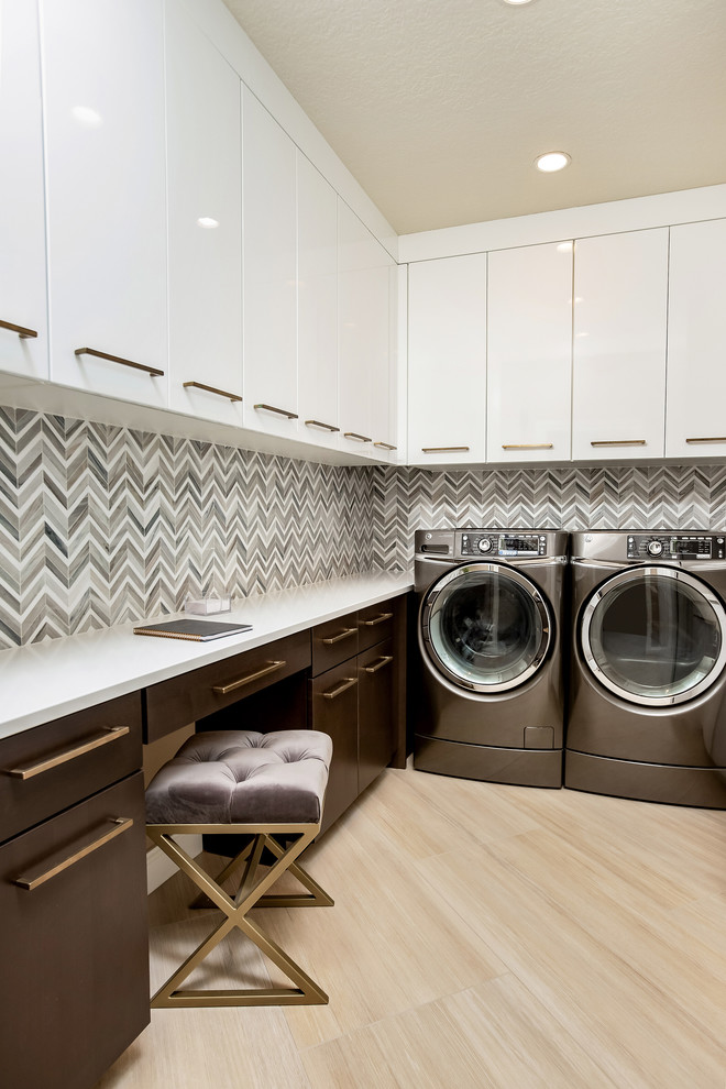 Photo of a large contemporary u-shaped separated utility room in Miami with flat-panel cabinets, white cabinets, engineered stone countertops, multi-coloured walls, light hardwood flooring, a side by side washer and dryer, beige floors and white worktops.