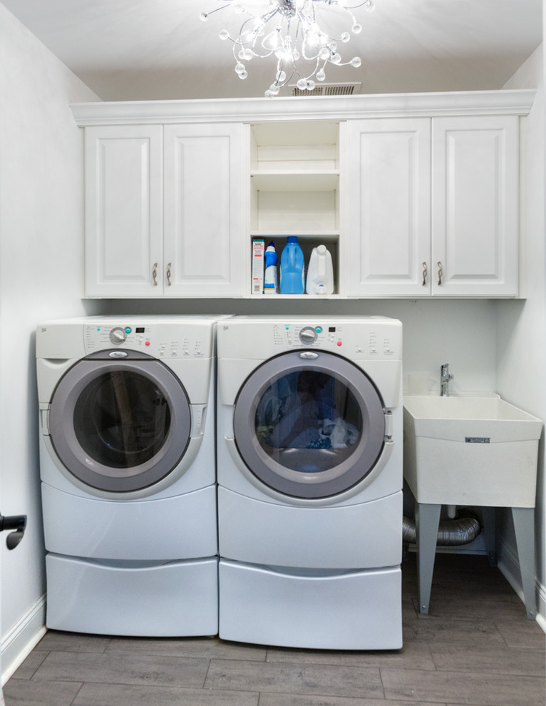 Inspiration for a small classic utility room in Chicago with an utility sink, raised-panel cabinets, white cabinets, white walls, ceramic flooring and a side by side washer and dryer.