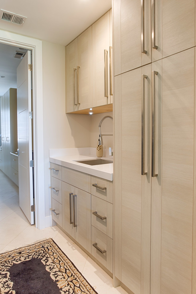 Immagine di una sala lavanderia design di medie dimensioni con lavello a vasca singola, ante lisce, ante in legno chiaro, pareti beige, pavimento in linoleum, lavatrice e asciugatrice affiancate e pavimento beige