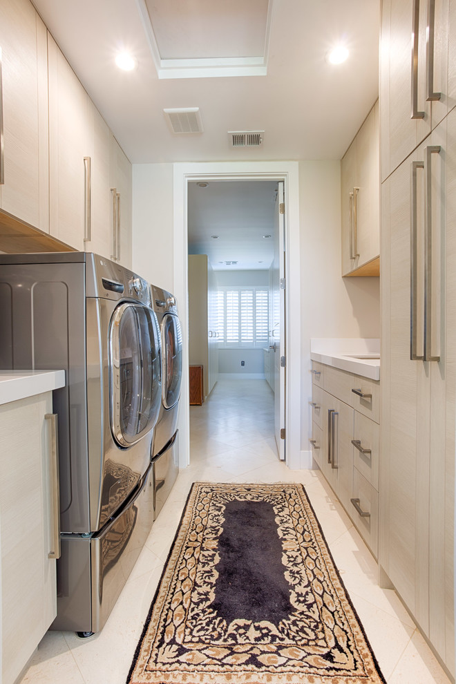 Esempio di una sala lavanderia design di medie dimensioni con ante lisce, ante in legno chiaro, pareti beige, pavimento in linoleum, lavatrice e asciugatrice affiancate, pavimento beige e lavello a vasca singola