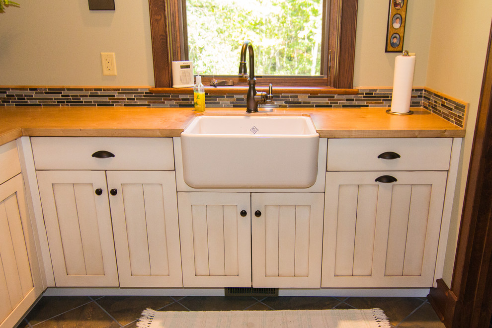 Inspiration for a large farmhouse laundry room remodel in Other with a farmhouse sink, recessed-panel cabinets, wood countertops, beige walls, a side-by-side washer/dryer and beige cabinets