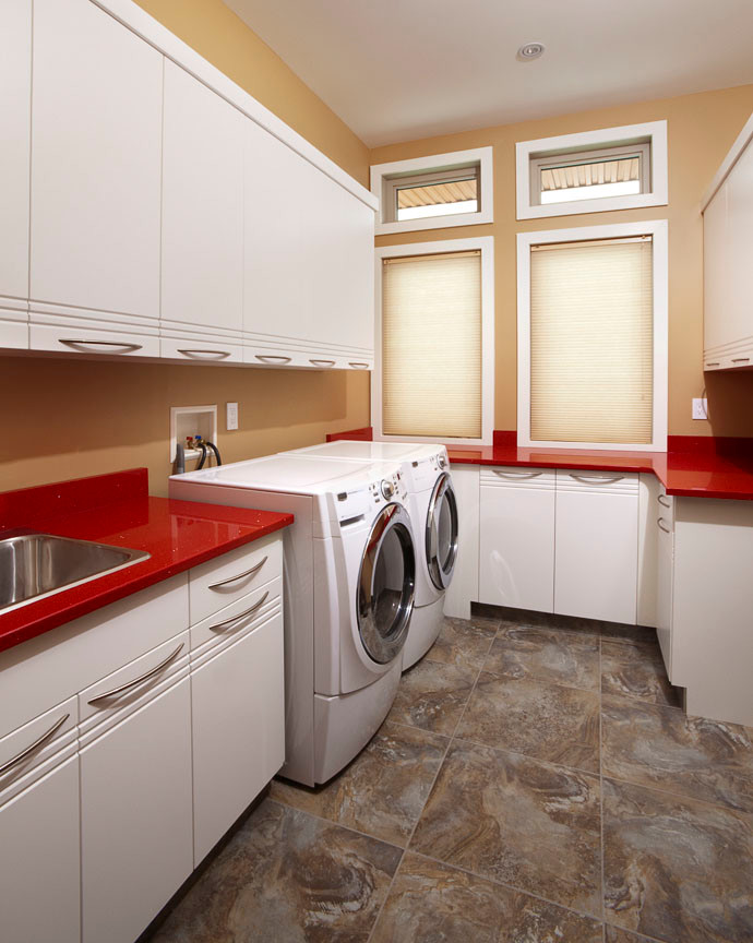 Imagen de lavadero minimalista con encimeras rojas