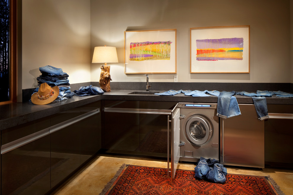 Diseño de lavadero contemporáneo con puertas de armario negras y encimeras negras
