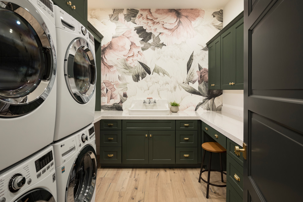 Large transitional u-shaped light wood floor and beige floor dedicated laundry room photo in Phoenix with shaker cabinets, green cabinets, multicolored walls, quartz countertops, a stacked washer/dryer, white countertops and a drop-in sink