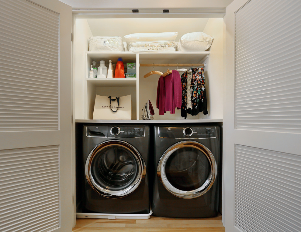 Imagen de armario lavadero lineal tradicional renovado pequeño con armarios abiertos, puertas de armario blancas, encimera de madera, paredes blancas, suelo de madera clara y lavadora y secadora juntas