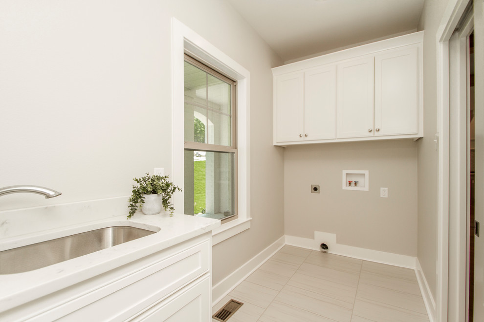 Medium sized classic single-wall separated utility room in Little Rock with a submerged sink, recessed-panel cabinets, white cabinets, engineered stone countertops, beige walls, porcelain flooring, a side by side washer and dryer, beige floors and white worktops.