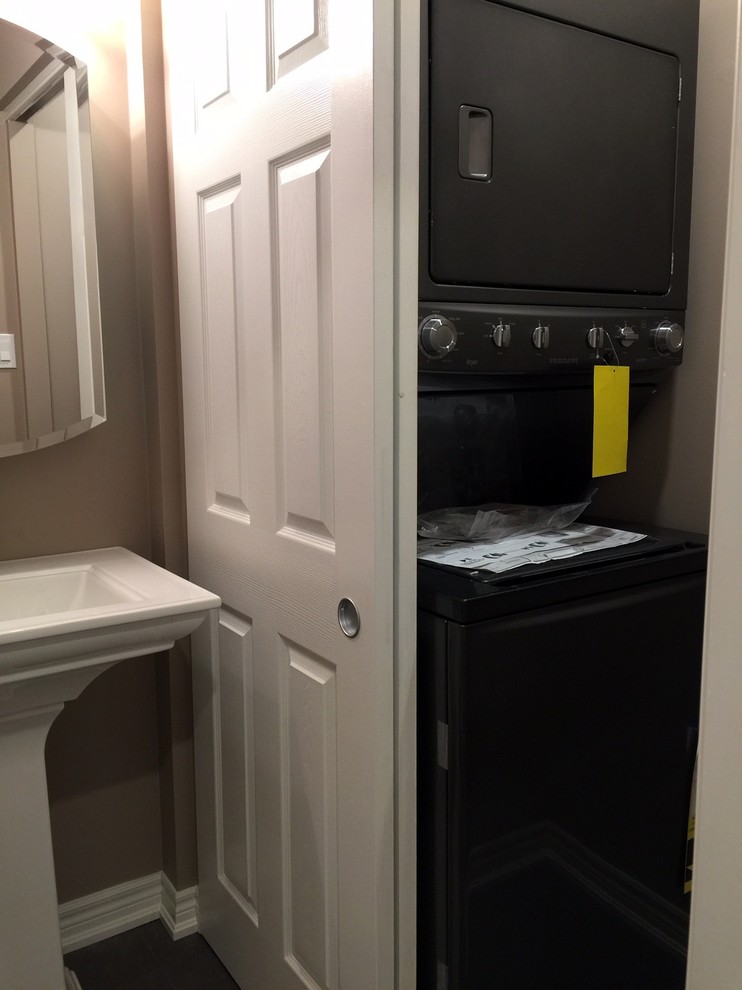 Small elegant laundry closet photo in Toronto with a stacked washer/dryer