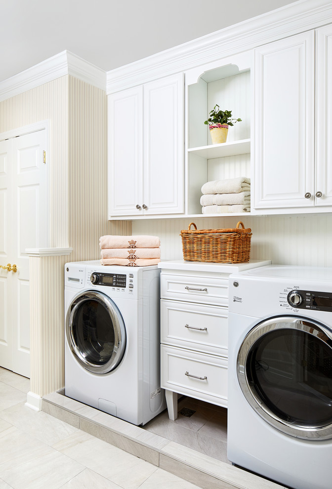 ワシントンD.C.にあるトラディショナルスタイルのおしゃれな洗濯室 (レイズドパネル扉のキャビネット、白いキャビネット、ベージュの壁、左右配置の洗濯機・乾燥機、ベージュの床、白いキッチンカウンター) の写真