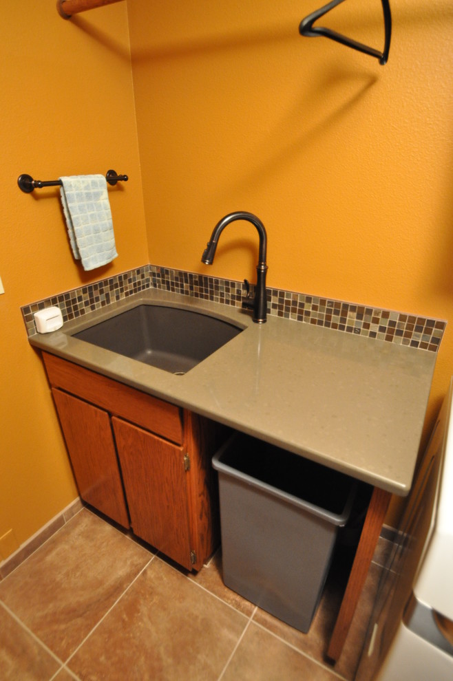 Exempel på en mellanstor eklektisk parallell tvättstuga enbart för tvätt, med en undermonterad diskho, bänkskiva i kvarts, klinkergolv i porslin, en tvättmaskin och torktumlare bredvid varandra och orange väggar