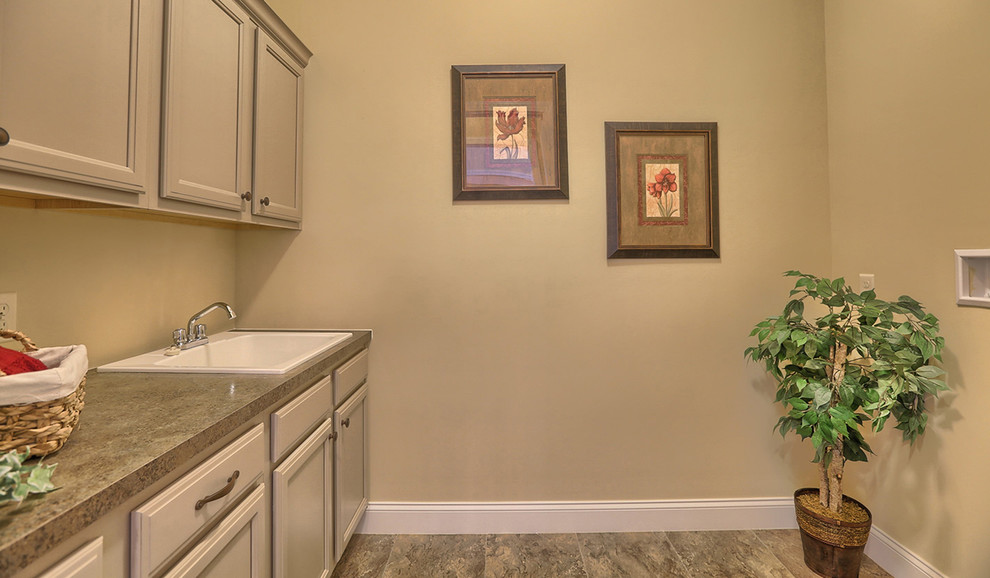 Photo of an expansive traditional galley utility room in Other with an utility sink, laminate countertops, beige walls, ceramic flooring and a side by side washer and dryer.