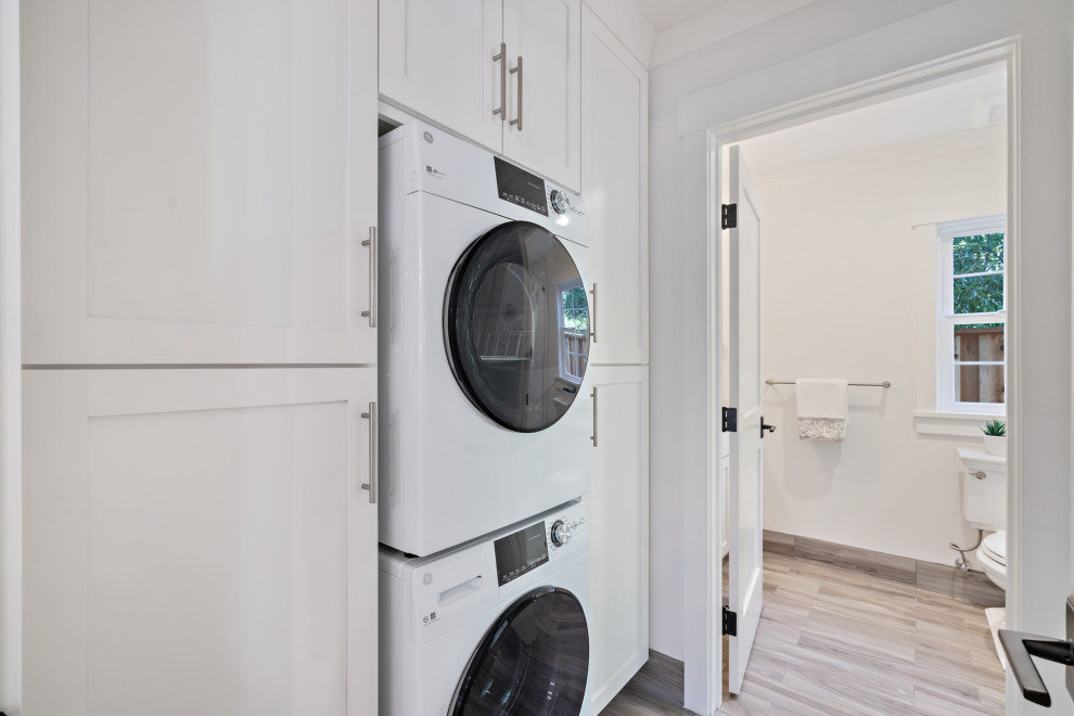 Dedicated laundry room - mid-sized craftsman single-wall porcelain tile and gray floor dedicated laundry room idea in San Francisco with an undermount sink, shaker cabinets, white cabinets, quartz countertops, gray walls, a stacked washer/dryer and white countertops