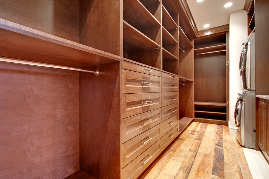 Rustic wardrobe in Calgary with medium wood cabinets, medium hardwood flooring and recessed-panel cabinets.