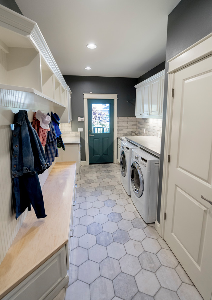 Photo of a large traditional galley utility room in Portland with raised-panel cabinets, white cabinets, quartz worktops, grey walls, marble flooring, a side by side washer and dryer, grey floors and a built-in sink.
