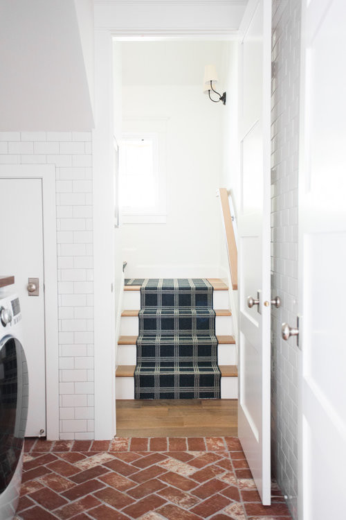 Esempio di una sala lavanderia stile marino di medie dimensioni con ante bianche, top in legno, pareti bianche, pavimento in mattoni, lavatrice e asciugatrice affiancate e pavimento rosso