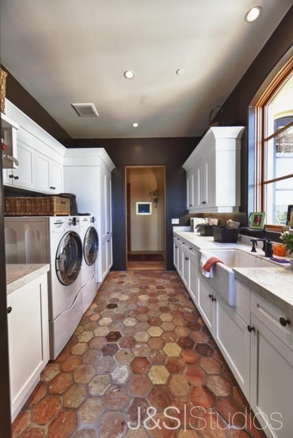 Inspiration för klassiska tvättstugor enbart för tvätt, med en rustik diskho, vita skåp, blå väggar och en tvättmaskin och torktumlare bredvid varandra