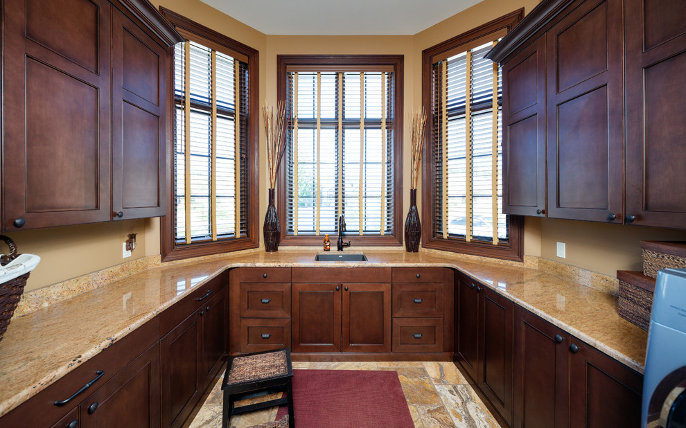 Inspiration for a mid-sized timeless u-shaped ceramic tile utility room remodel in Grand Rapids with an undermount sink, recessed-panel cabinets, dark wood cabinets, granite countertops, beige walls and a side-by-side washer/dryer