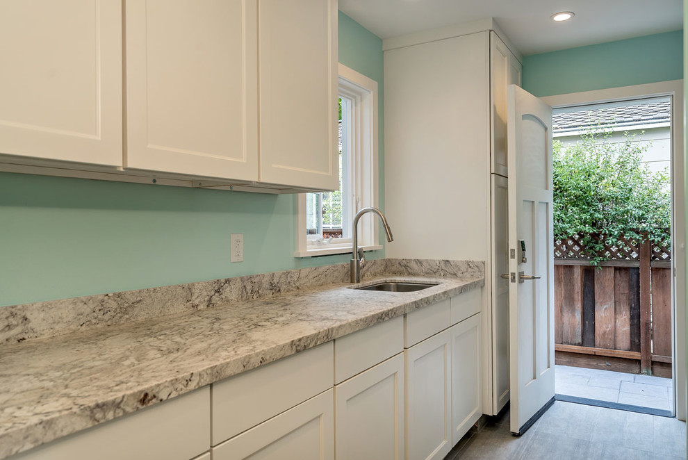 Photo of an expansive classic u-shaped separated utility room in San Francisco with a submerged sink, shaker cabinets, white cabinets, marble worktops, green walls, porcelain flooring, a side by side washer and dryer, grey floors and grey worktops.