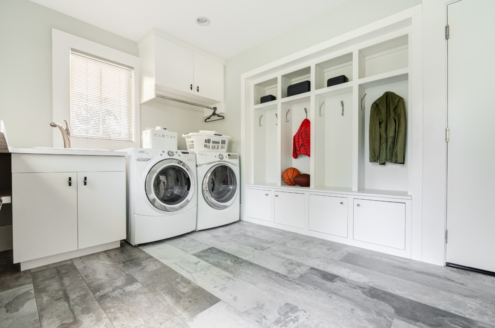 This is an example of a large contemporary galley utility room in New York with a built-in sink, open cabinets, white cabinets, white walls, porcelain flooring and a side by side washer and dryer.
