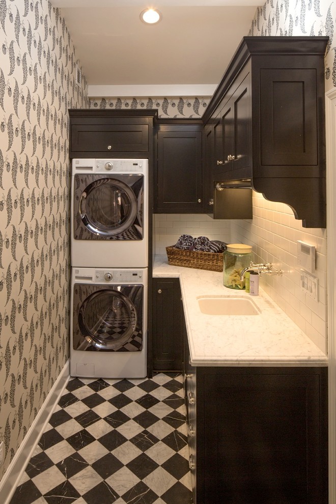 Foto di una sala lavanderia tradizionale di medie dimensioni con lavello sottopiano, ante in stile shaker, ante nere, top in marmo, pareti grigie, pavimento in marmo e lavatrice e asciugatrice a colonna