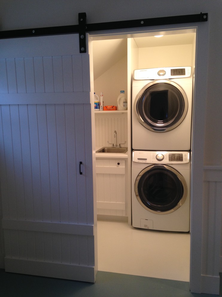 ニューヨークにある高級な中くらいなトランジショナルスタイルのおしゃれな洗濯室 (L型、ドロップインシンク、白いキャビネット、木材カウンター、白い壁、塗装フローリング、上下配置の洗濯機・乾燥機) の写真
