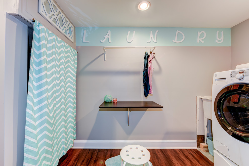 Foto di una piccola sala lavanderia tradizionale con lavatoio, top in legno, pareti grigie, pavimento in legno massello medio e lavatrice e asciugatrice affiancate
