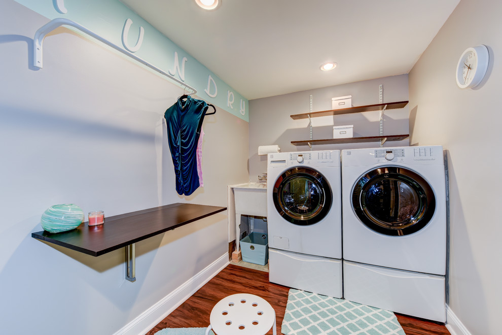 Kleine Klassische Waschküche in L-Form mit Ausgussbecken, Arbeitsplatte aus Holz, grauer Wandfarbe, braunem Holzboden und Waschmaschine und Trockner nebeneinander in Philadelphia
