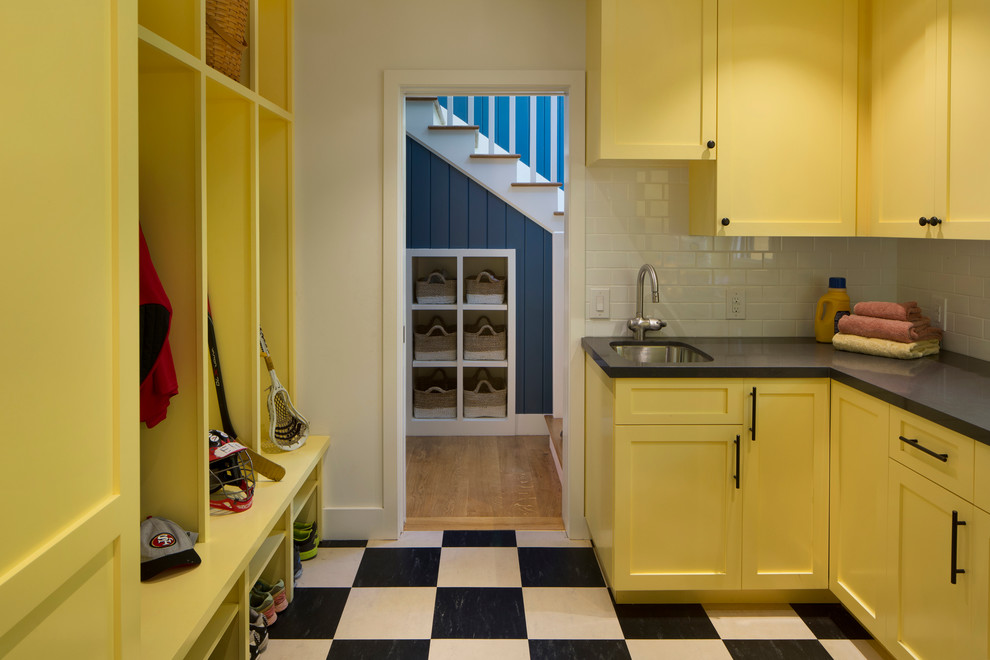 Idéer för ett stort amerikanskt u-format grovkök, med gula skåp, vita väggar, en undermonterad diskho, luckor med infälld panel, bänkskiva i täljsten, klinkergolv i keramik och flerfärgat golv