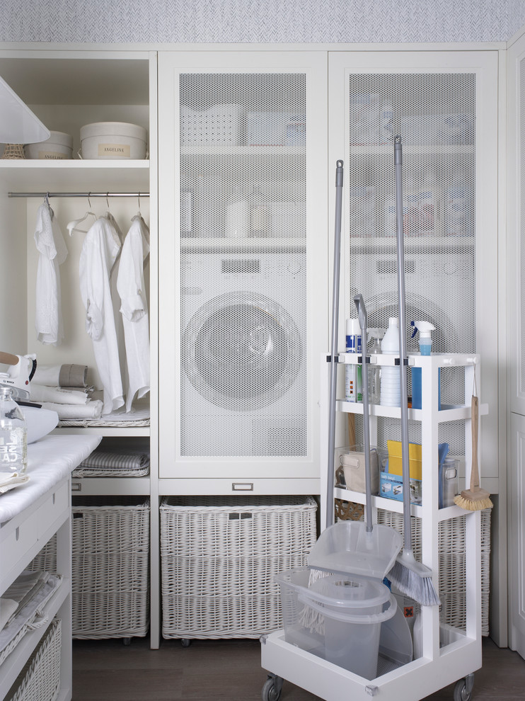 Modelo de lavadero multiusos nórdico de tamaño medio con paredes blancas y lavadora y secadora juntas