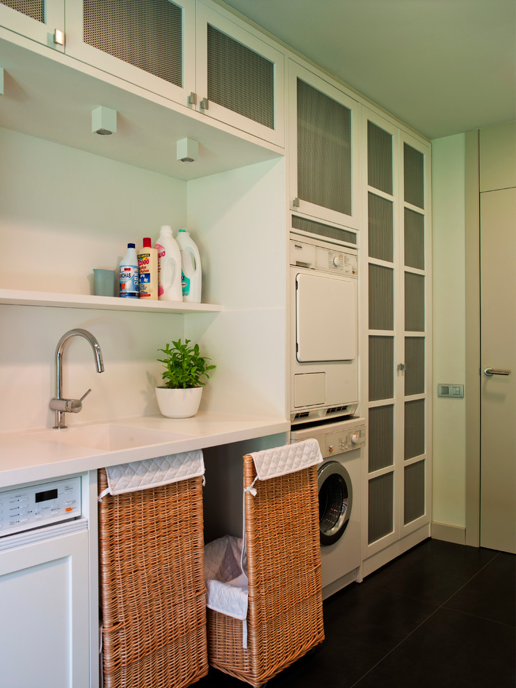 Inspiration for a large contemporary laundry room remodel in Barcelona with an integrated sink and a stacked washer/dryer