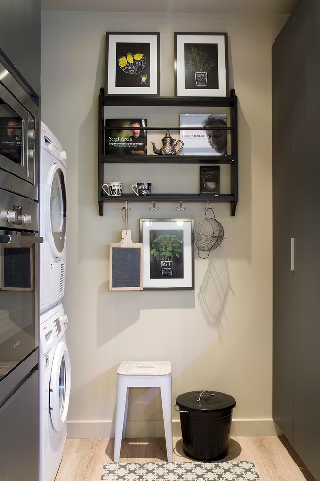 Foto di una piccola lavanderia contemporanea con ante lisce, ante grigie, pareti beige, parquet chiaro e lavatrice e asciugatrice a colonna