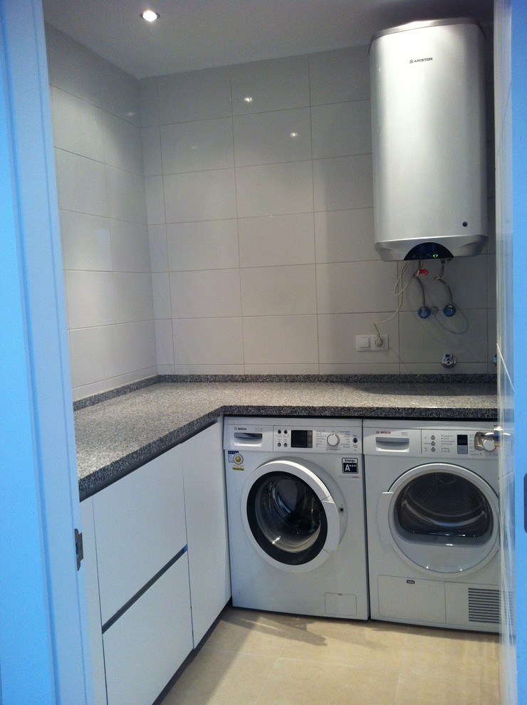 Diseño de cuarto de lavado en L clásico renovado pequeño con armarios con paneles lisos, puertas de armario blancas, encimera de granito, paredes blancas y lavadora y secadora juntas