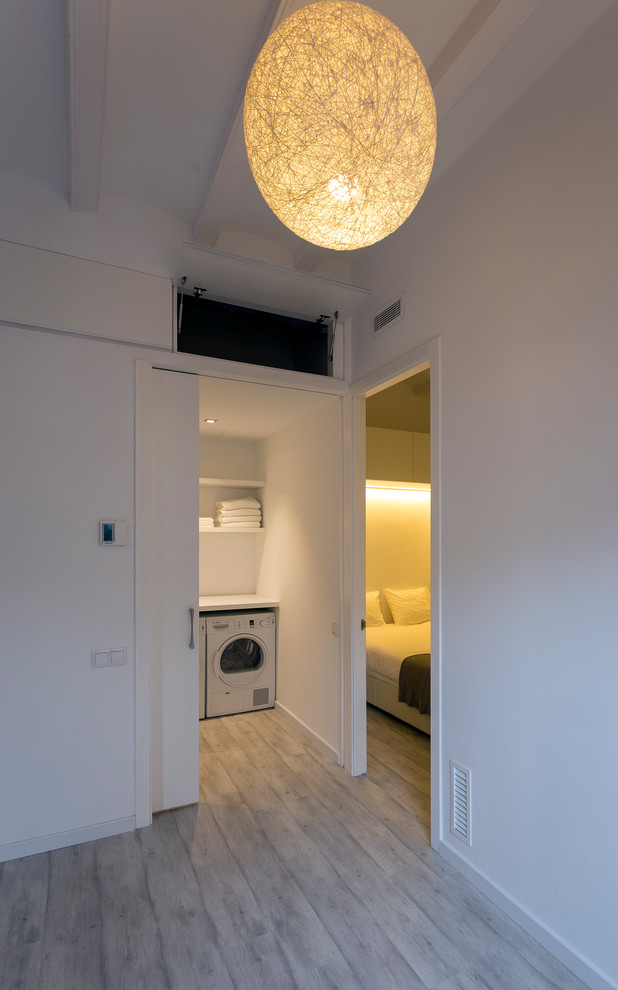 Diseño de cuarto de lavado lineal contemporáneo pequeño con armarios abiertos, paredes blancas y lavadora y secadora juntas