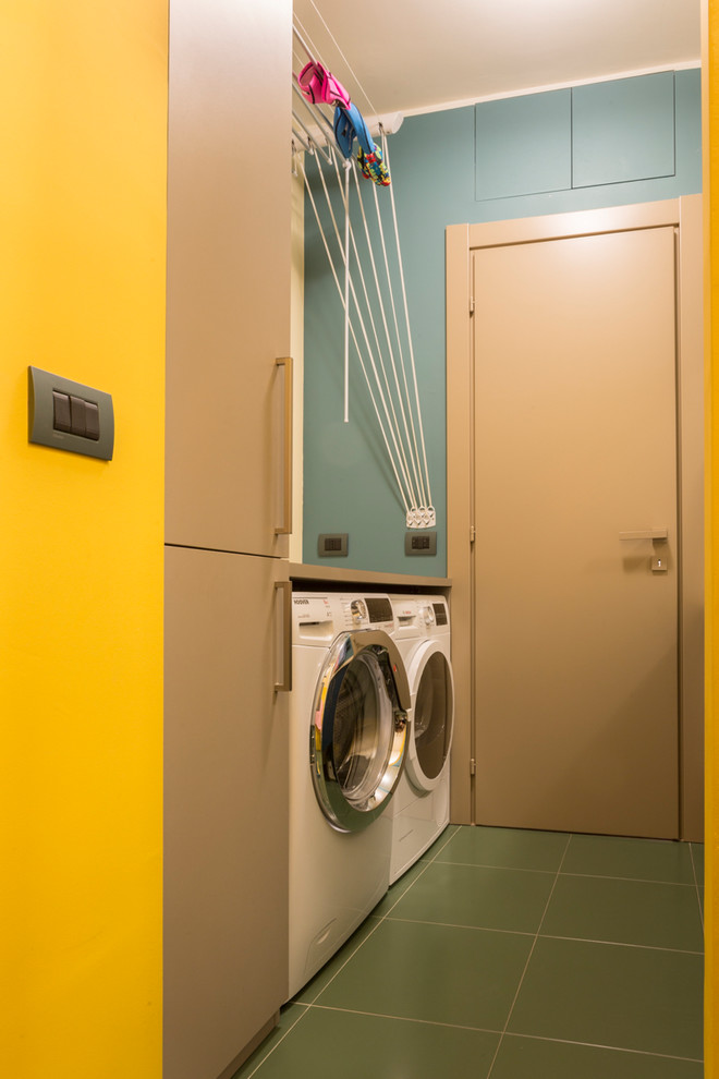 Immagine di una lavanderia contemporanea di medie dimensioni con pareti blu, lavatrice e asciugatrice affiancate e pavimento verde
