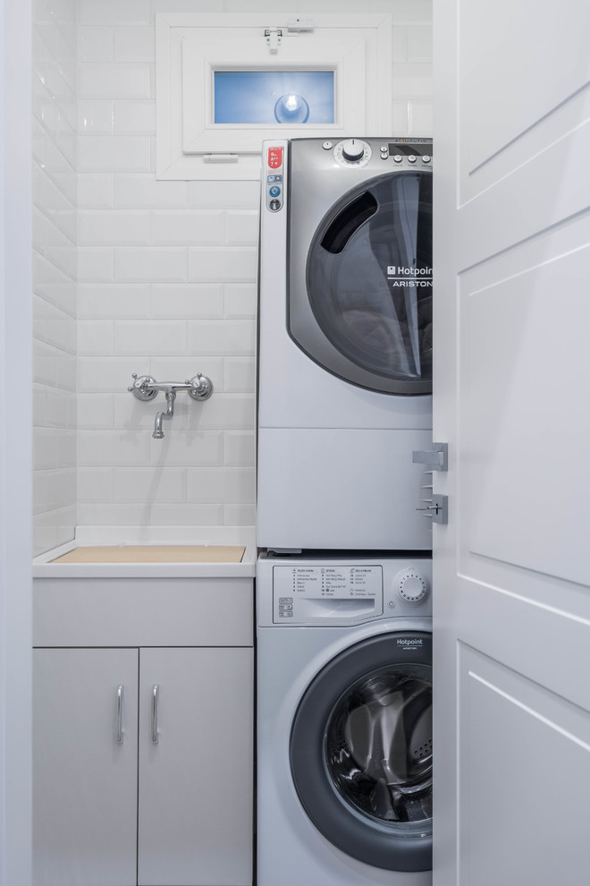 Esempio di una lavanderia design con lavatrice e asciugatrice a colonna