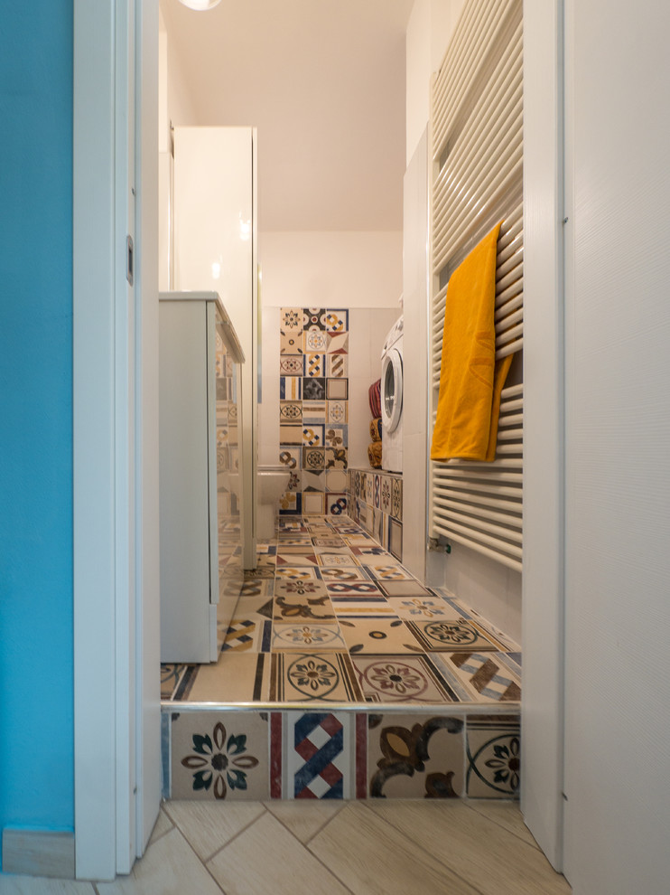 Inspiration for a small bohemian galley utility room in Milan with a single-bowl sink, flat-panel cabinets, white cabinets, laminate countertops, multi-coloured walls, ceramic flooring and a side by side washer and dryer.