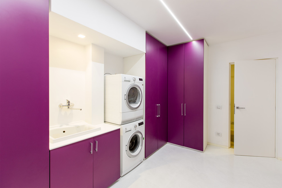 Einzeilige Moderne Waschküche mit Einbauwaschbecken, flächenbündigen Schrankfronten, weißer Wandfarbe und Waschmaschine und Trockner gestapelt in Sonstige