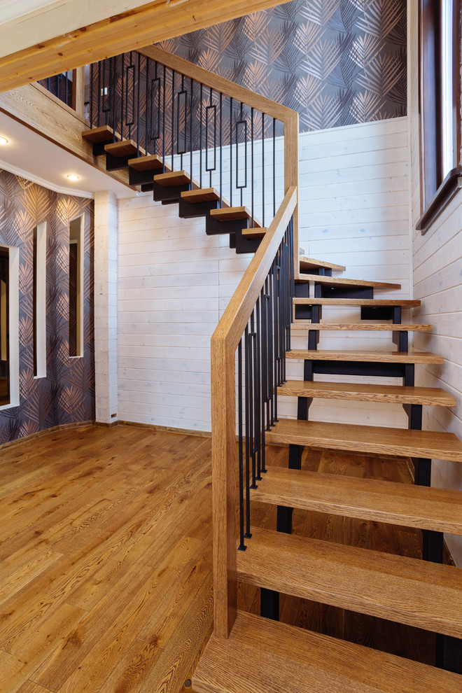 Foto de escalera en L clásica renovada de tamaño medio con escalones de madera y barandilla de metal