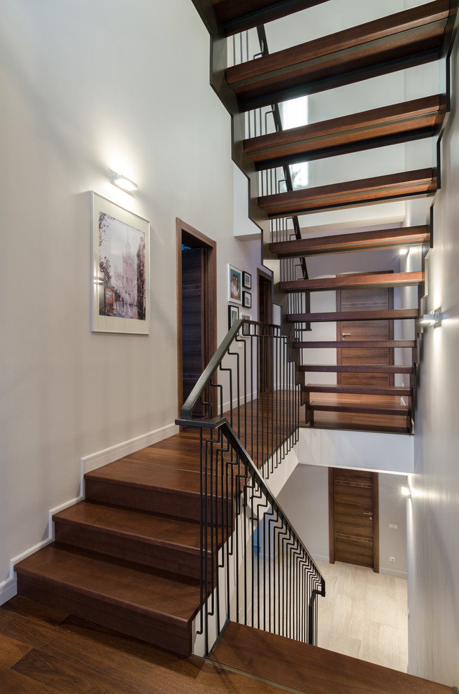 Imagen de escalera en U actual sin contrahuella con escalones de madera y barandilla de metal
