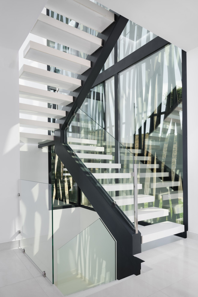 Стильный дизайн: п-образная лестница в стиле модернизм с стеклянными перилами без подступенок - последний тренд
